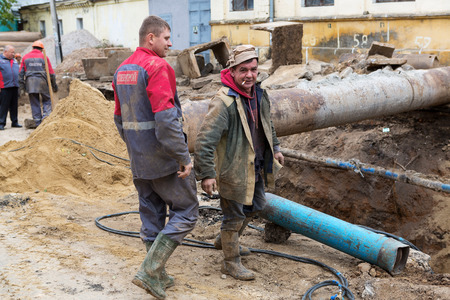 Odessa, Ukraine - October 11, 2016: Repair of heating duct. The workers, welders made by electric welding and gas welding on large iron pipes at a depth of excavated trench.のeditorial素材