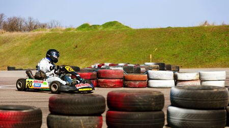 ODESSA, UKRAINE - APRIL 2, 2017: Competitions on the picture, pilots in helmet and in racing clothes participate in the card race. Carting show. Children and adult racers on bright branded maps.のeditorial素材