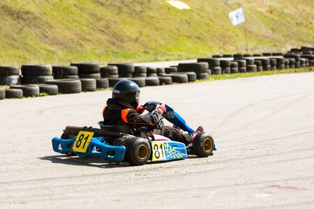 ODESSA, UKRAINE - APRIL 2, 2017: Competitions on the picture, pilots in helmet and in racing clothes participate in the card race. Carting show. Children and adult racers on bright branded maps.のeditorial素材