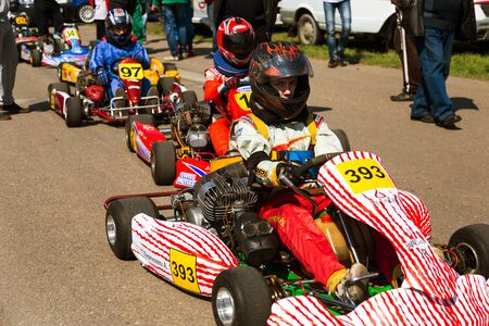 ODESSA, UKRAINE - APRIL 2, 2017: Competitions on the picture, pilots in helmet and in racing clothes participate in the card race. Carting show. Children and adult racers on bright branded maps.のeditorial素材
