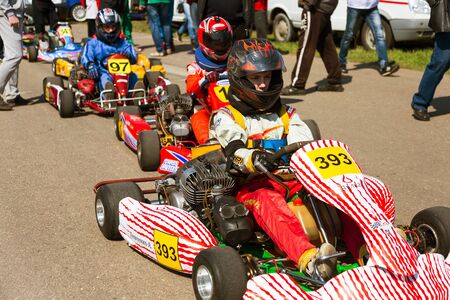 ODESSA, UKRAINE - APRIL 2, 2017: Competitions on the picture, pilots in helmet and in racing clothes participate in the card race. Carting show. Children and adult racers on bright branded maps.のeditorial素材