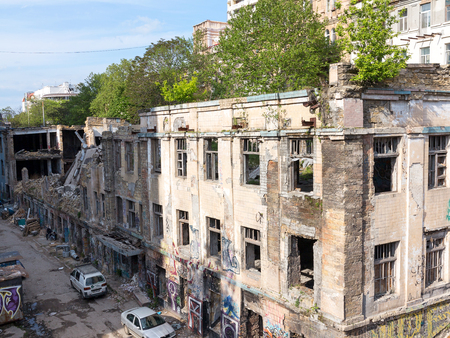 Odessa, Ukraine - May 17, 2017: Panoramic view of the street with decaying houses in a poor neighborhood. Ruined building after a natural disaster. Provide shelter for homeless people and drug addicts.のeditorial素材