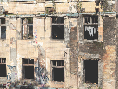 Old abandoned high-rise building in the city centre on a summer day. Social inequality. Crumbling residential building inhabited by poor people and luxury villas in Odessaのeditorial素材