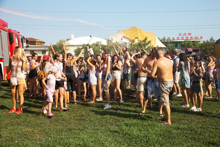 ODESSA, UKRAINE - August 5, 2017: Water festival. Party wet. Hands and happy people crowd partying under rain at holi fest, festival of colors in summer, amazing moment. Color festのeditorial素材