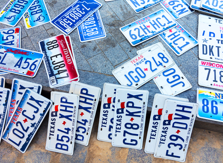 Odessa, Ukraine - circa 2017: car numbers from around the world on display. Discontinued the license plate of cars from cars of Europe and the United States on the paving tiles. Vintage background antique license plates of Europe and the Statesのeditorial素材