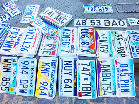 Odessa, Ukraine - circa 2017: car numbers from around the world on display. Discontinued the license plate of cars from cars of Europe and the United States on the paving tiles. Vintage background antique license plates of Europe and the Statesのeditorial素材