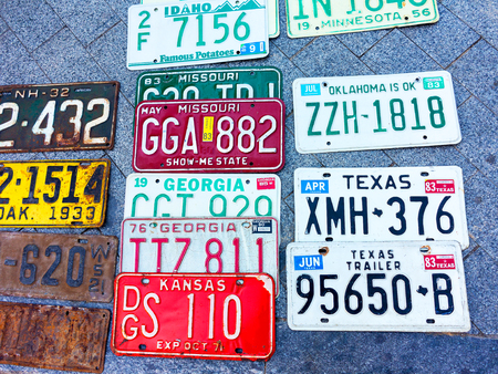 Odessa, Ukraine - circa 2017: car numbers from around the world on display. Discontinued the license plate of cars from cars of Europe and the United States on the paving tiles. Vintage background antique license plates of Europe and the Statesのeditorial素材