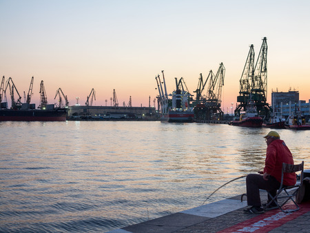 Varna, Bulgaria - July 23, 2016: View on seaport with cranes, cargo and passenger ships at sunset, Varna.のeditorial素材
