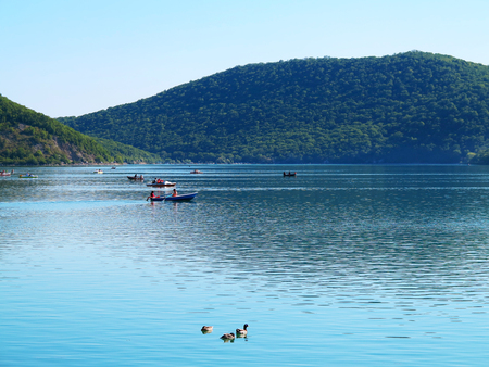 Abrau-Durso - May 5, 2018: People on boats swim on Lake Abrau on a warm spring day. Abrau-Durso, Krasnodar Region, Russiaのeditorial素材