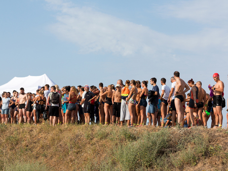 ODESSA, UKRAINE - August 21, 2018: A lot of athletes on the beach, waiting for the start, at the Race Nation swimming competition. Professional athlete in triathletes trains for an ironman.のeditorial素材