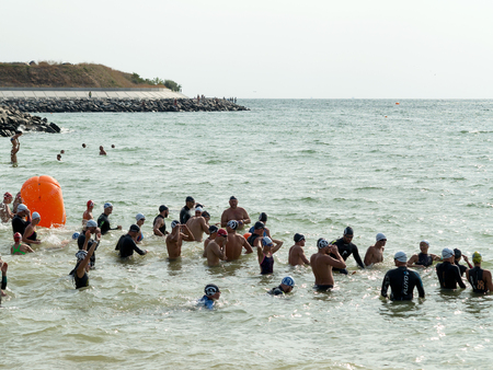 ODESSA, UKRAINE - August 21, 2018: Many swimmers started in sea at Race Nation. Many Professional athlete in triathletes trains for an ironman. Sportsman beautifully floats in sea at competitionsのeditorial素材