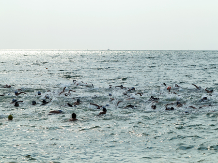 ODESSA, UKRAINE - August 21, 2018: Many swimmers started in sea at Race Nation. Many Professional athlete in triathletes trains for an ironman. Sportsman beautifully floats in sea at competitionsのeditorial素材