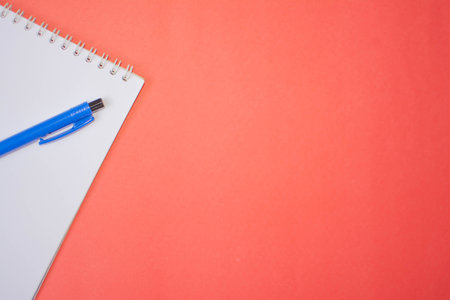 Blue pen and notebook on pink backgroundの写真素材