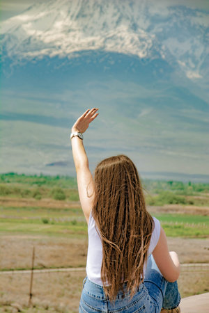Beautiful long-haired girl on a mountain backgroundの写真素材