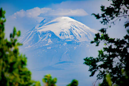 Beautiful landscape with a mountain. The top of the mountain is covered with white snowの写真素材