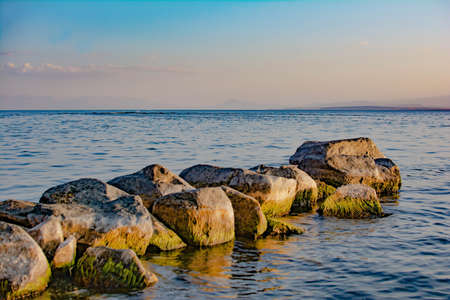 Stone path to the sea. Beautiful seascape with large stones on the sea. Blue sea and a pile of stonesの写真素材