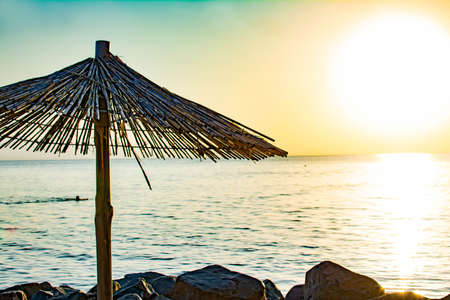 Rest at the sea. Wooden beach umbrellas on the seashore. Beautiful seascapeの写真素材
