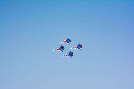 Aviation pilots demonstrate high aerobatics on fighters. Aircraft bombers in the blue sky. Military aircraft in the skyの写真素材