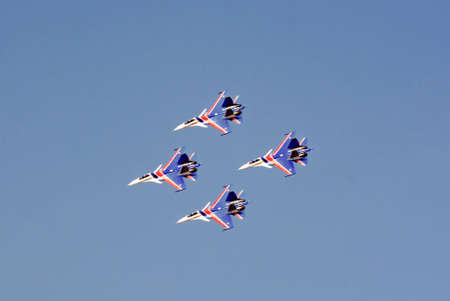 Aviation pilots demonstrate high aerobatics on fighters. Aircraft bombers in the blue sky. Military aircraft in the skyの写真素材