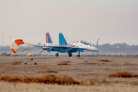 A military plane landed on the ground with an open parachute. Bomber plane made landing at the...