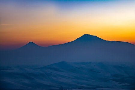 The peak of the mountain is covered with clouds. Red clouds at the peak of the mountain during sunset. Beautiful sunsetの写真素材