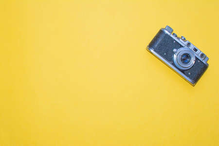 Old camera and on a yellow background. Metal photo camera and yellow background for designers and photo studioの写真素材