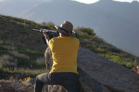 Hunter with a gun. Man holding a gun in his handsの写真素材