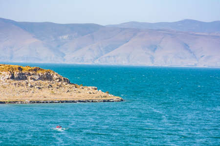 The boat rushes to the peninsula in the sea. Beautiful sea landscape