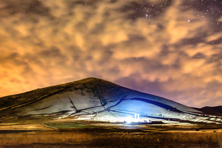 Starry sky and lonely mountain. The stars are shining in the sky