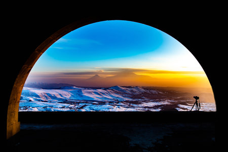 Silhouette of a photographer on the background of the mountains at sunsetの写真素材