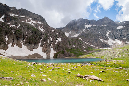 Mountain landscape with lake and cloudy sky in summer, Kyrgyzstanの写真素材