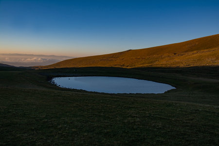 Icelandic landscape with lake and mountains in the background at sunsetの写真素材