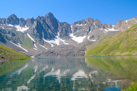 Mountain lake with clear water and reflection of mountains in the waterの写真素材