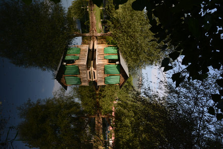 Reflection in the water of a wooden house on a sunny dayの写真素材