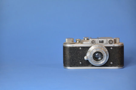 Vintage film camera on blue background with copy space for text.の写真素材