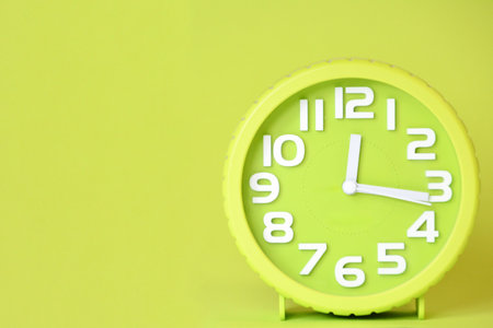 Green alarm clock on green background with copy space for your text.の写真素材