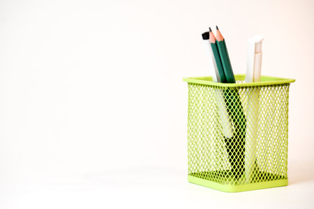 Pencils in a green basket on a white background.の写真素材