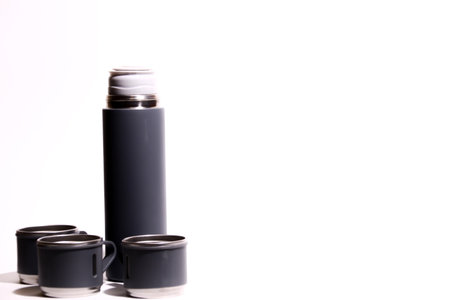 Black thermos on a white background with space for text.の写真素材