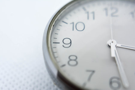 Close up of clock face on white background, business time concept.の写真素材