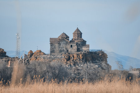 Armenian church in Lake Sevan. Monastery on the river bank. Winter landscape with temple and lakeの写真素材