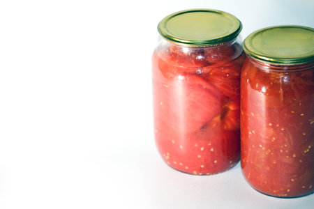 Tomato in a glass jar on a white background.の写真素材