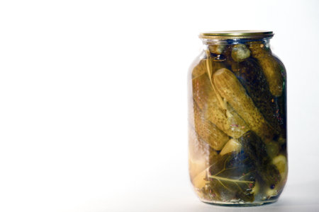 Pickled cucumbers in a glass jar on a white background.の写真素材