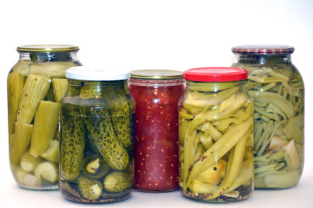 Jars with pickled cucumbers and tomatoes on a white backgroundの写真素材