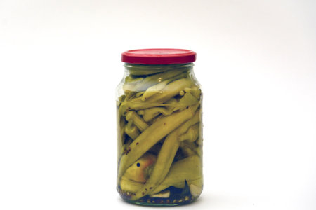 pickled green beans in a glass jar on a white background.の写真素材