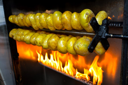 Potatoes on a spit in the oven, close-up.の写真素材