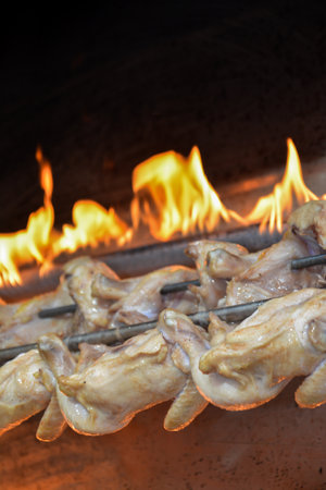Grilled chicken on a spit in a restaurant, close-upの写真素材