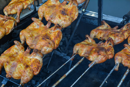 Grilled chicken on a spit in the open air, close-upの写真素材