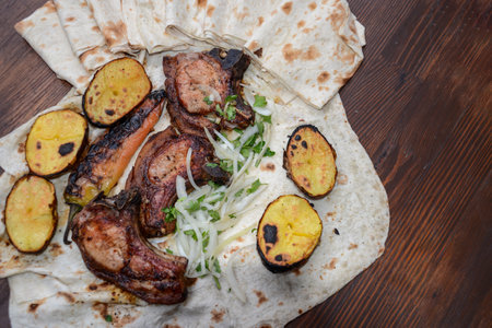 Pork ribs with grilled potato and onion on a pita breadの写真素材