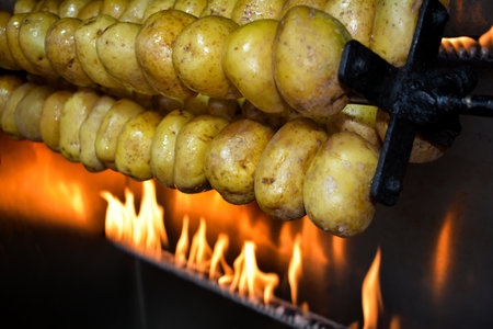Roasted potatoes on a spit in a barbecue, close-upの写真素材