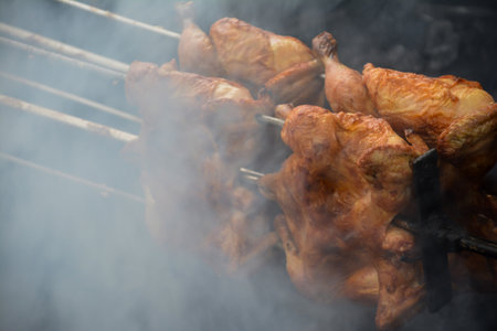 Roasted chicken on skewers in smoke. Selective focus.の写真素材